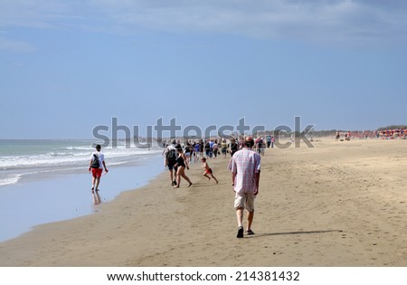 GRAN CANARIA, SPAIN - APRIL 15: Tourists walking on the beach Playa del Ingles, Grand Canary Island. April 15, 2010 in Gran Canaria, Spain