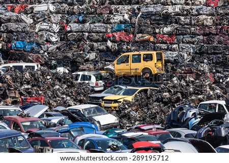 Stacked wrecked cars going to be shredded in a recycling plant