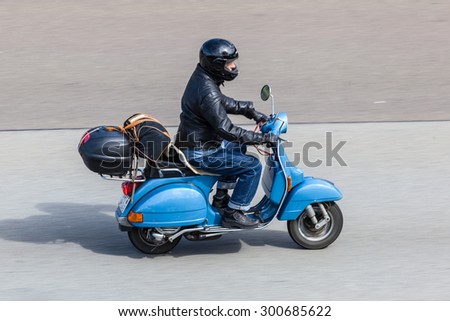 FRANKFURT, GERMANY - JULY 26: Blue Vespa scooter moving fast on tarmac road near Frankfurt. July 26, 2015 in Frankfurt Main, Germany