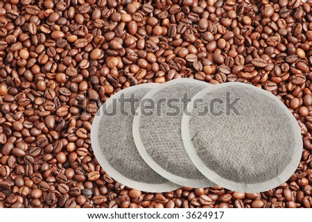 Coffee pads isolated over coffee beans background with clipping-path included