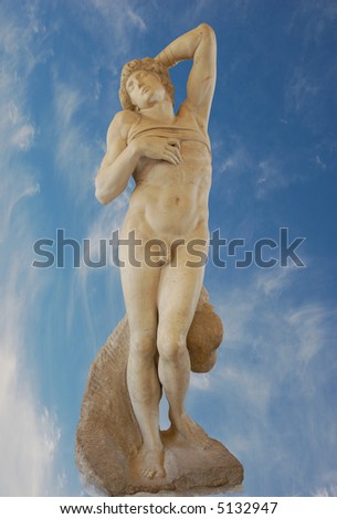 Ancient Roman statue against blue sky