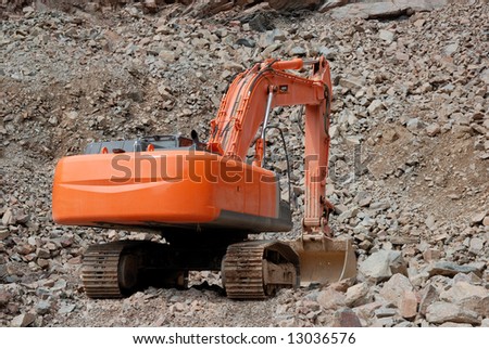 Red excavator in a stone pit
