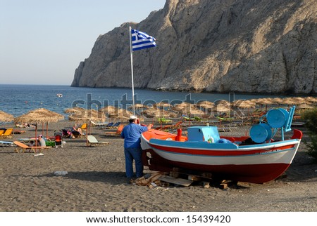 Fisherman painting his boat in Santorini, Greece
