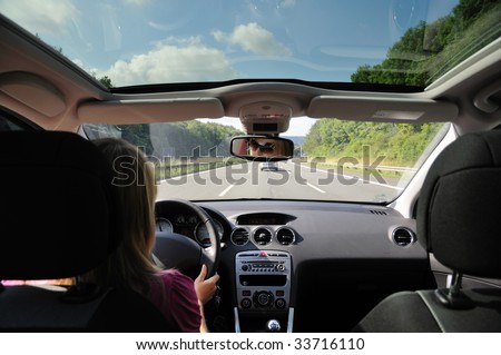 Young woman driving with her car