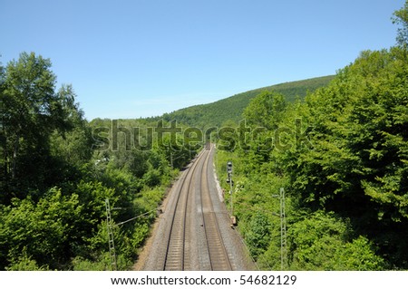 Railroad track running through a green landscape