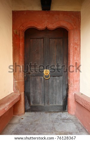 Ancient door with golden lion door knock