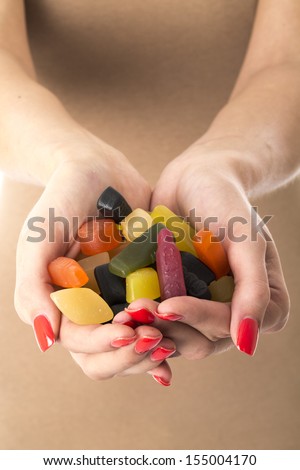Model Released. Attractive Young Woman Holding a Handful of Sweets