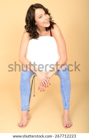 Happy Smiling Young Woman Sitting in a White Chair Relaxing in Bare Feet