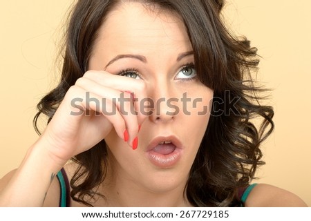 Attractive Young Woman Crying Wiping Away a Tear From Her Eye