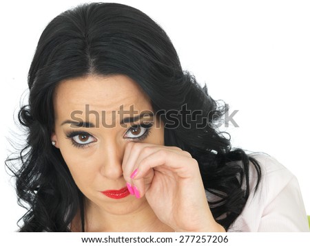 Portrait of a Beautiful Young Hispanic Woman in Her Twenties Wiping Her Eye Looking Upset