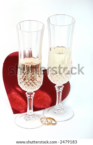 Pair of glasses with wedding rings and heart for toast.