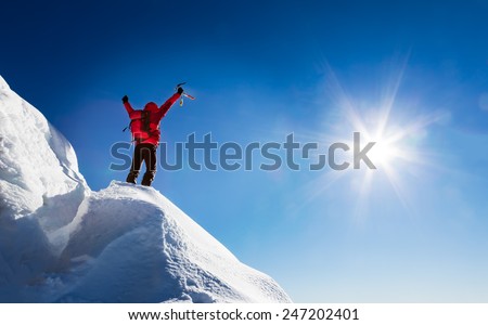 Mountaineer celebrates the conquest of the summit. Concepts: victory, success, achievement, triumph.