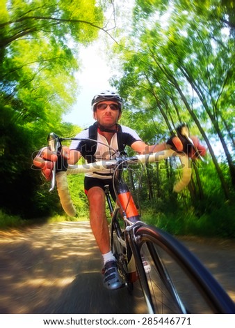 Road bike; male cyclist riding a racing bike downhill. Front view, large copy space. Sport and active life concept.