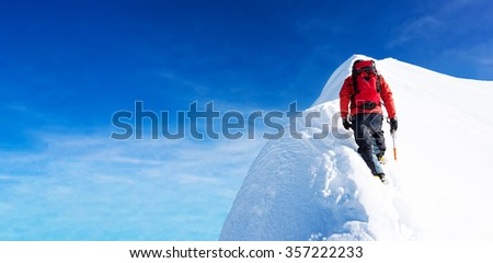 Mountaineer arrive to the summit of a snowy peak. Concepts: determination, courage, effort, self-realization. Clear sky, sunny day, winter season. Large copy-space on the left. European Alps, Europe.