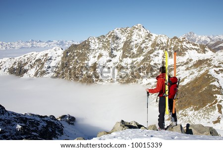 Male ski-climber at the summit of his climbing; horizontal frame. Italian alps.