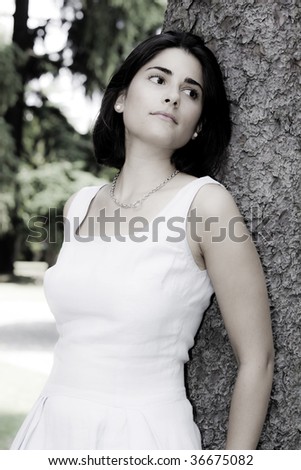 Vertical portrait of a young latin girl, black haired, dressed in white