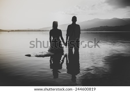 bride and groom on the water in the lake at sunseet, trash the dress
