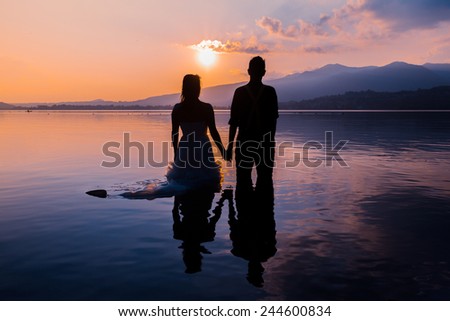 bride and groom on the water in the lake at sunseet, trash the dress