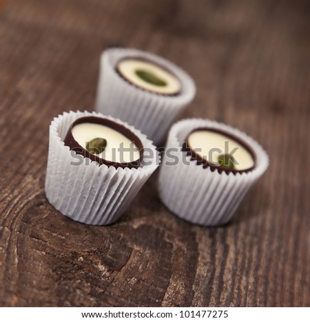 Chocolate sweets with pistachio on the wooden background