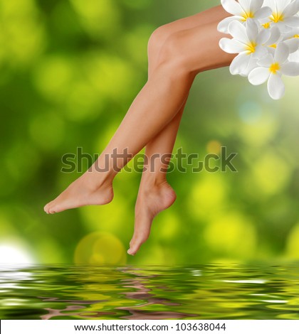Long woman legs  on green background. Spa concept