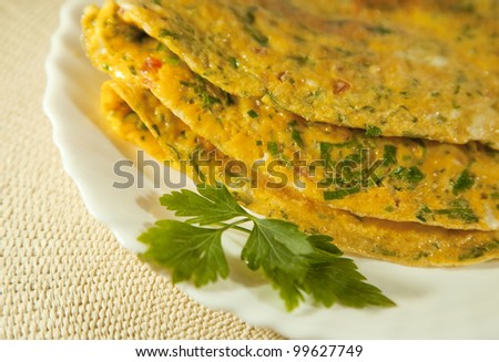 Scrambled eggs with herbs. Omelet on white plate