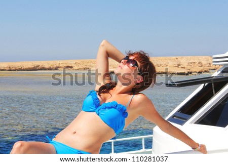The young girl in the sea on the yacht acquires a tan