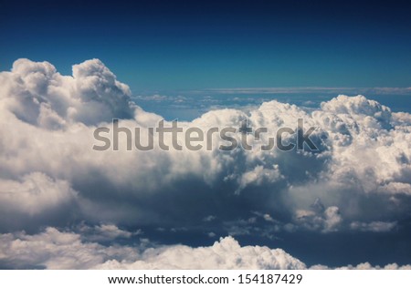 View of fluffy curly-headed clouds from plane height
