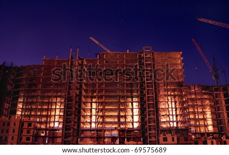 Night building with illumination elevating cranes and stars