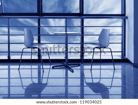 The large windows of the office, the round table and chairs.