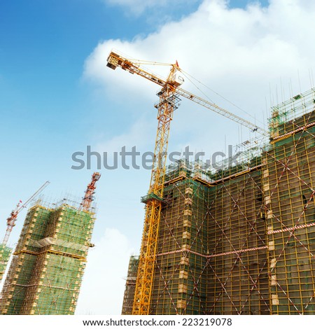 Construction site, workers and cranes.
