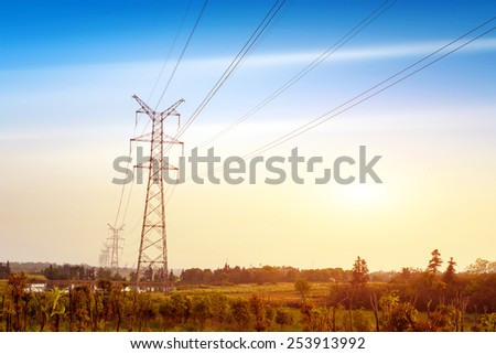 Electricity pylon against blue cloudy sky