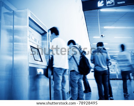 The subway, ticket machine, a group of people are waiting.