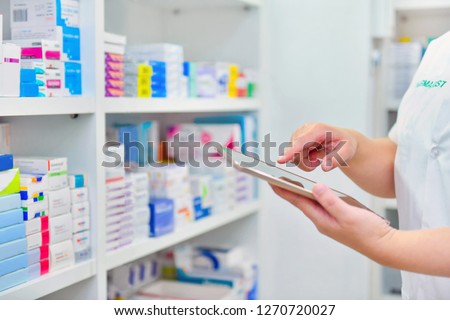 Pharmacist holding computer tablet Using for filling prescription in pharmacy drugstore.