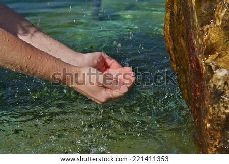 Beautiful woman hands in a mountain stream