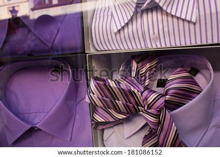 Well arranged boutique display window with a male shirts and a tie