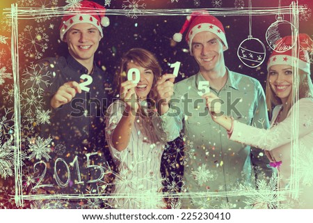 Four young people celebrating New Year, holding card numbers 2015
