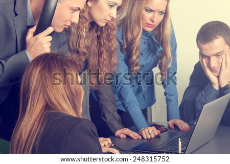 Team of business people anxiously watching computer and solving an important issue