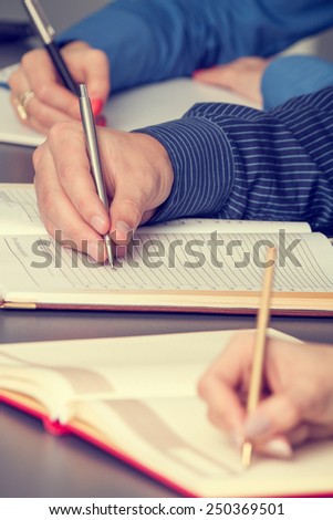 Group of young business people on a meeting taking notes
