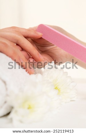 Woman in a nail salon receiving a manicure by a beautician