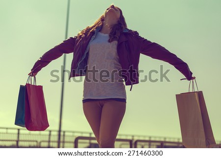 Beautiful, young brunette walking and feeling happy after successful shopping