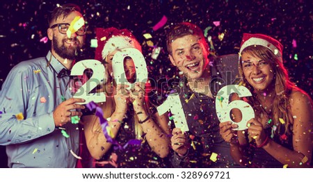 Two beautiful young couples having fun at New Year's Eve Party, holding cardboard numbers 2016