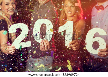 Two beautiful young couples having fun at New Year\'s Eve Party, holding cardboard numbers 2016