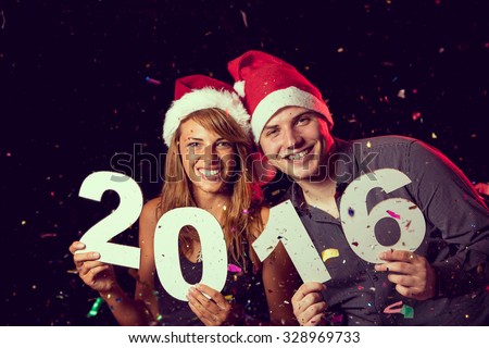 Beautiful, young couple celebrating New Year\'s Eve, holding cardboard numbers 2016