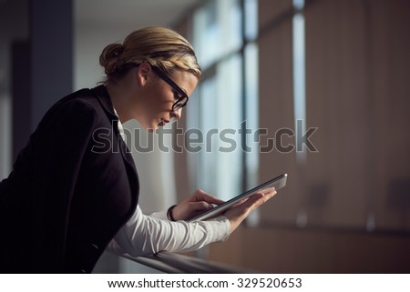 Strong, confident, business woman standing in an office building, holding tablet computer