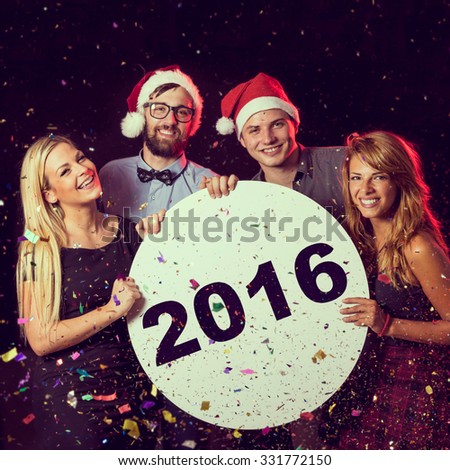 Group of friends having fun, celebrating New Year\'s Eve and holding cardboard circle with 2016 written on it