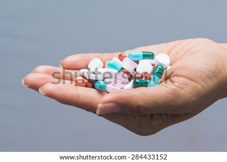 various tablets pills in hand, drug