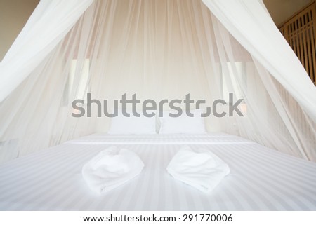 white mosquito net over a bed in a luxurious hotel, interior