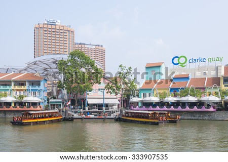 CLARK QUAY, SINGAPORE - OCTOBER 11, 2015: tourist boat cruising the Singapore river at Clarke Quay, Singapore on October 11, 2015, Landmark