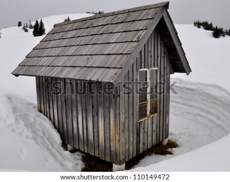 small wooden cabin surrounded by snow