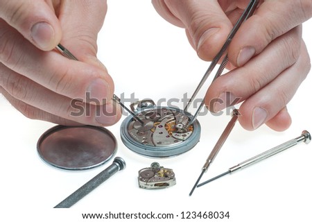 the watchmaker with tweezers and a screw-driver repairing an old pocket watch
